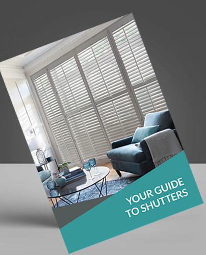 A brochure tilted against a grey background, featuring a lounge with large windows covered by white shutters, a blue armchair, a round coffee table, and the text YOUR GUIDE TO SHUTTERS in bold white letters.