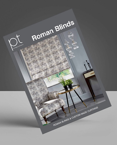 A brochure cover titled Roman Blinds features a room with patterned Roman blinds, a matching armchair, a small round table with plants, and a modern side table, set against a grey background.