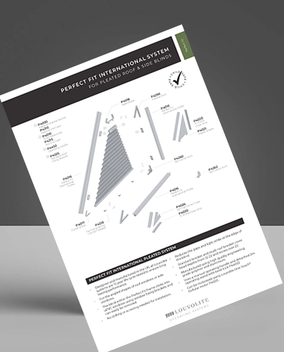 A printed instruction sheet titled Louvolite Perfect Fit International Blinds System for Pleated Roof & Side Blinds features diagrams, labelled parts, and assembly instructions on a white background. The sheet is tilted against a grey surface.